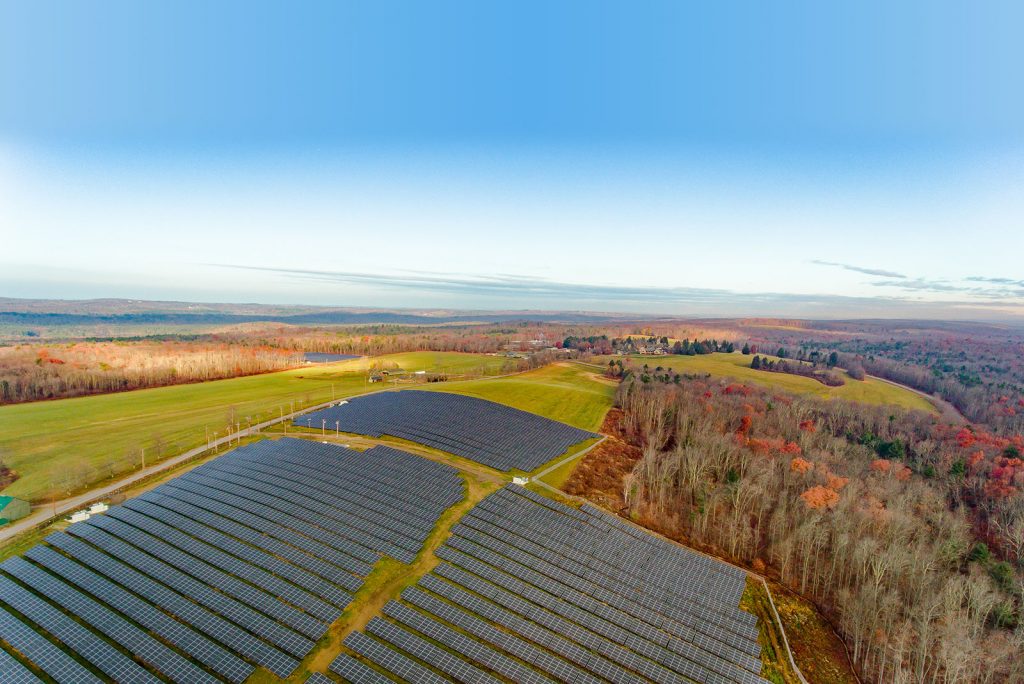 Community solar farm next to trees in winter