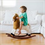 A little boy riding a wooden rocking horse
