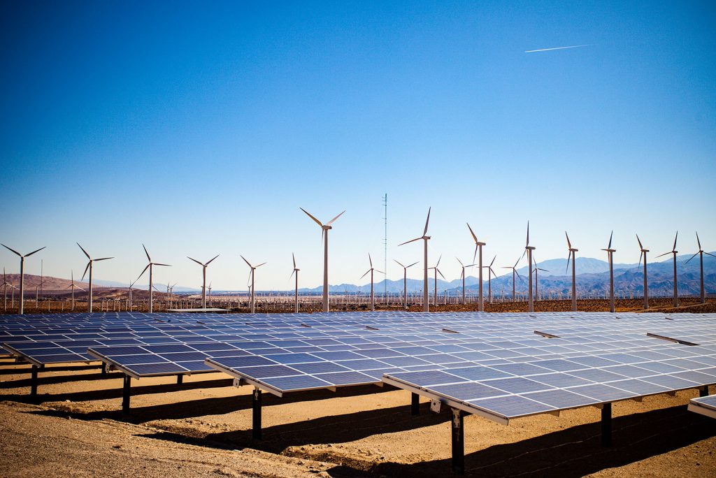 A community solar farm and wind farm next to each other