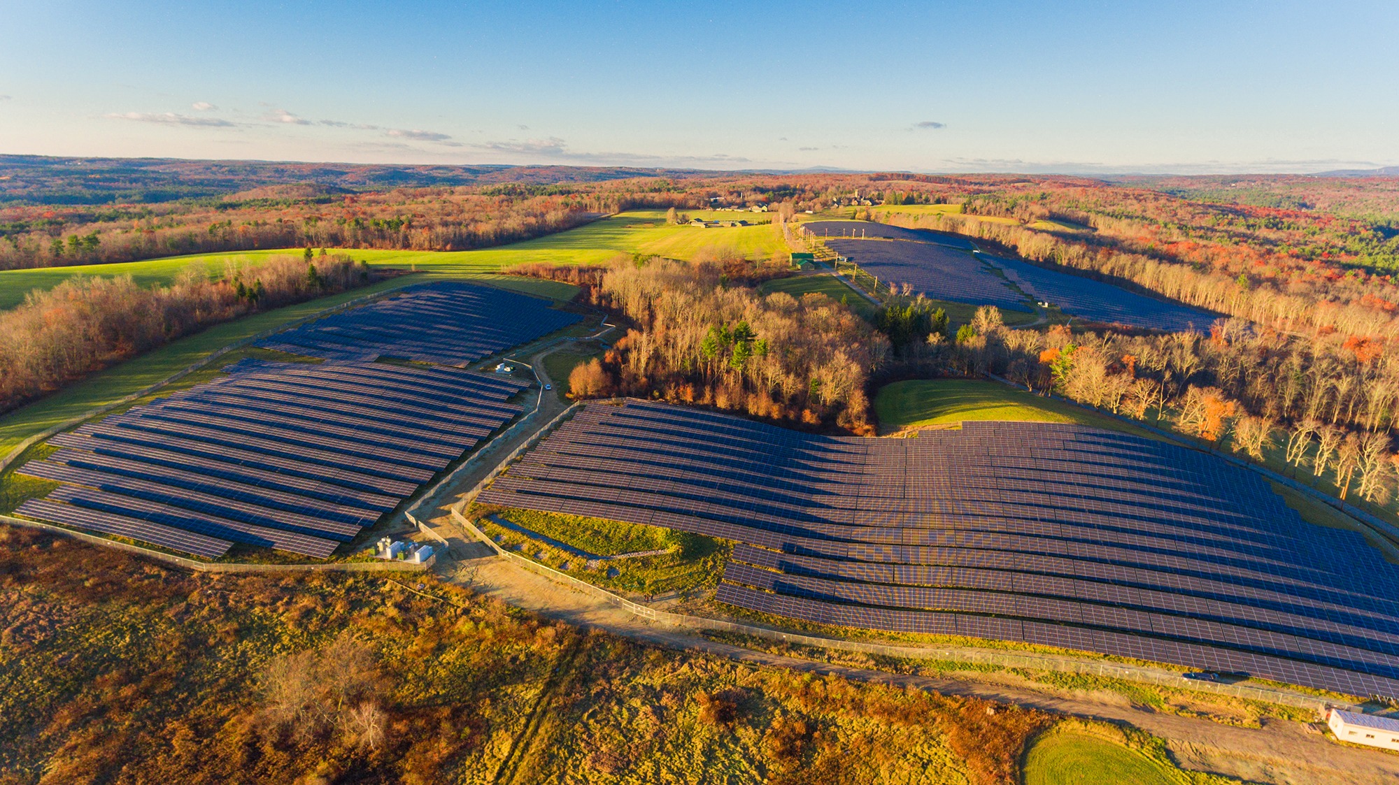 Aerial view of a community solar field with clear skies