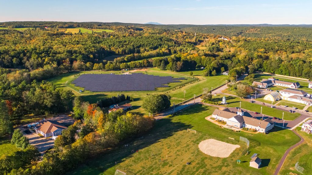 A community solar garden next to houses and trees