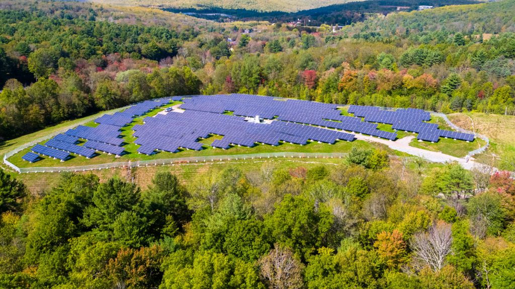 A community solar garden in Massachusetts surrounded by trees