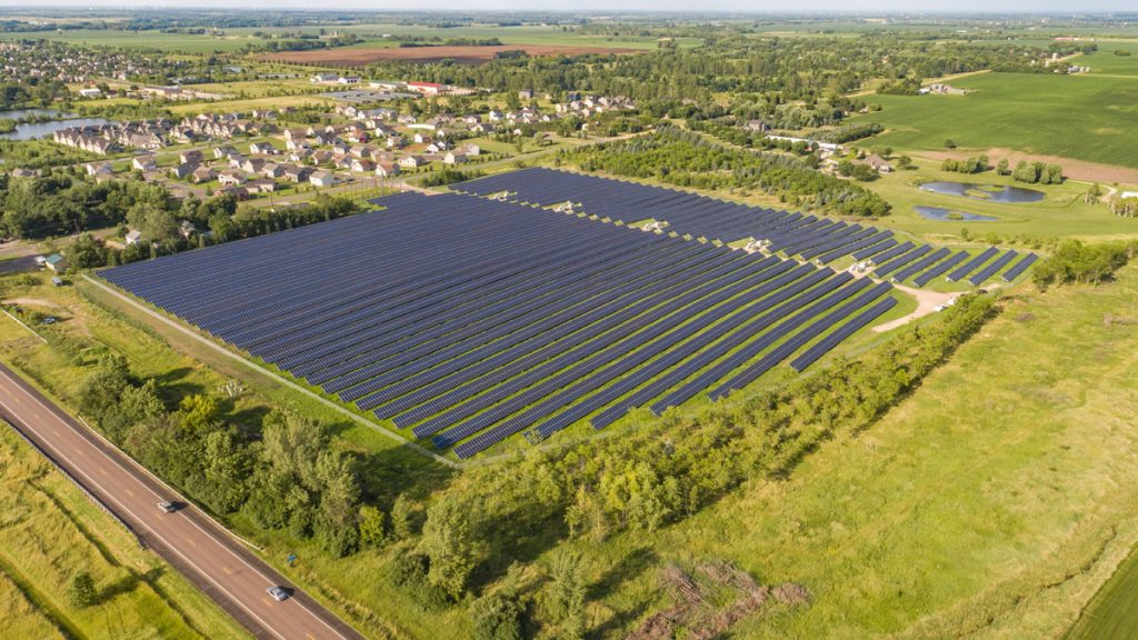 A community solar garden next to houses and a road