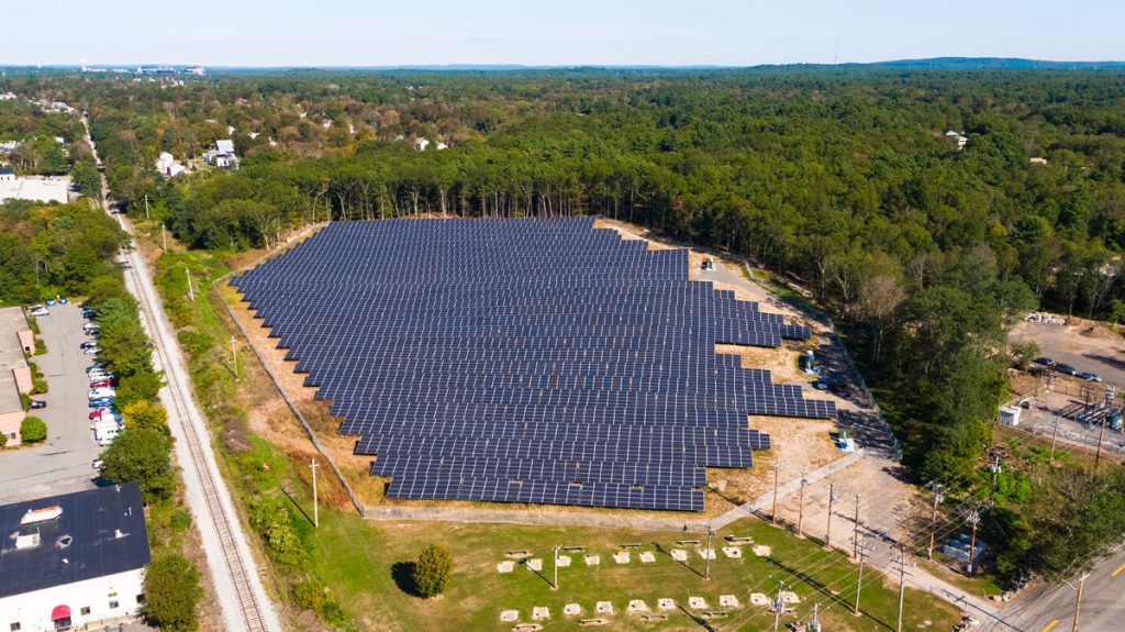 Community solar garden next to train tracks and trees