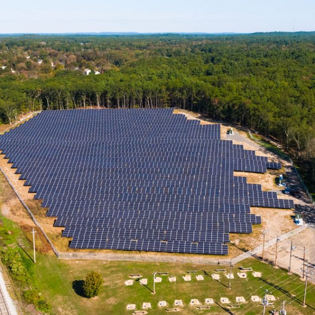 Community solar garden next to train tracks and trees
