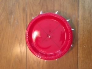 red plastic plate on top of foam circle with spoons