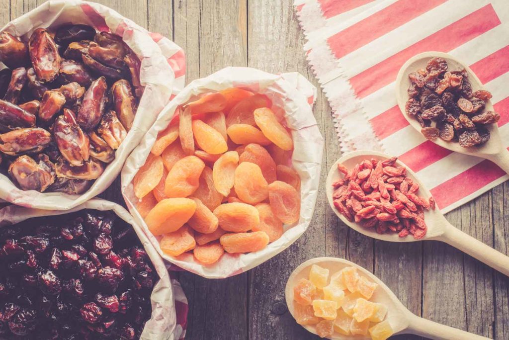 A table topped with dried fruits in different bowls