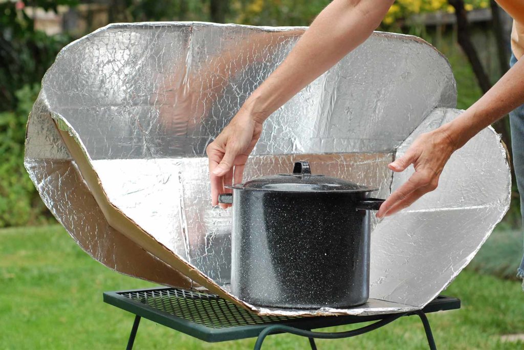 A metal cooking pot in a solar cooker