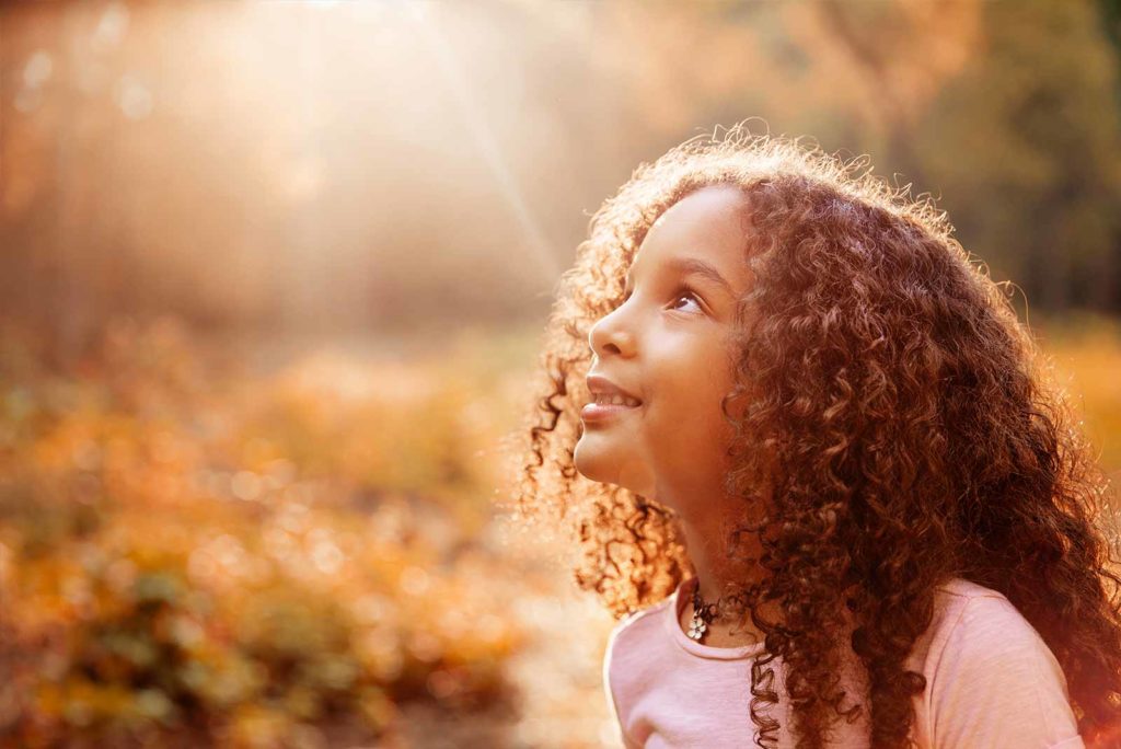 Young girl looking up at the sky