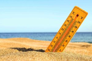 thermometer in sand near ocean