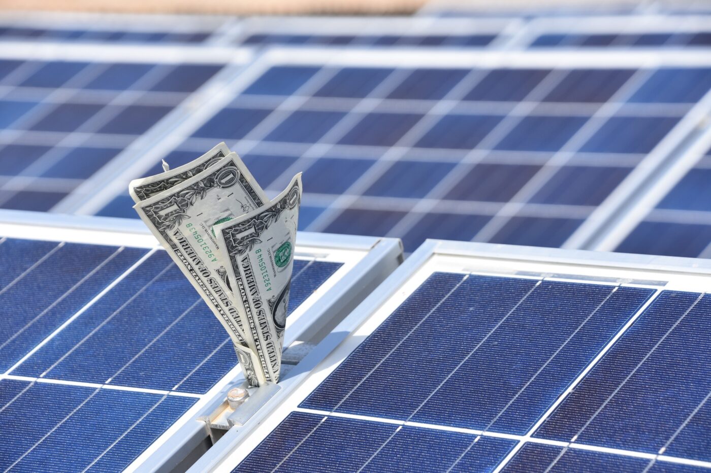 solar panels with dollar bills stuck in between them
