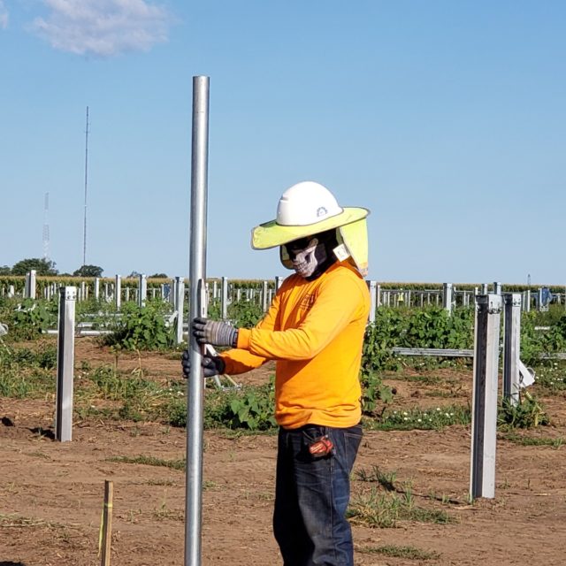man placing pole on foundation