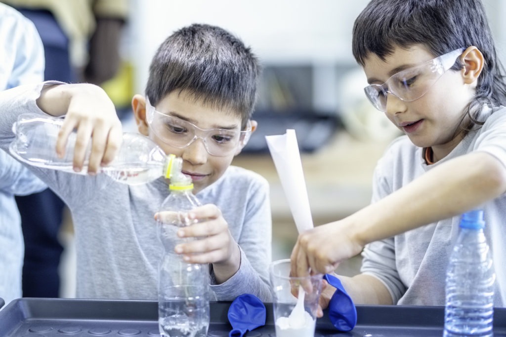 Two schoolboys doing experiment on science class.