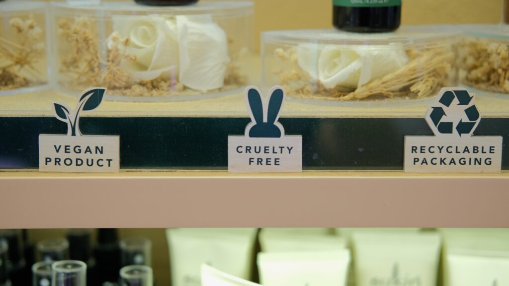 Store shelf with labels for ethical products, including vegan friendly, cruelty free, and recyclable packaging.